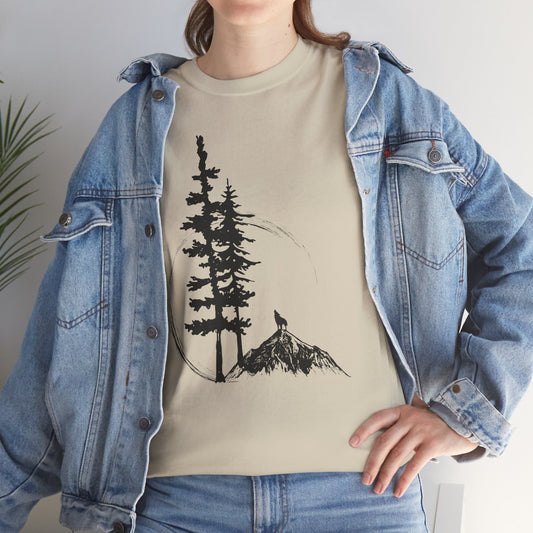 Person wearing a beige t-shirt with a tree and mountain design, paired with a denim jacket.